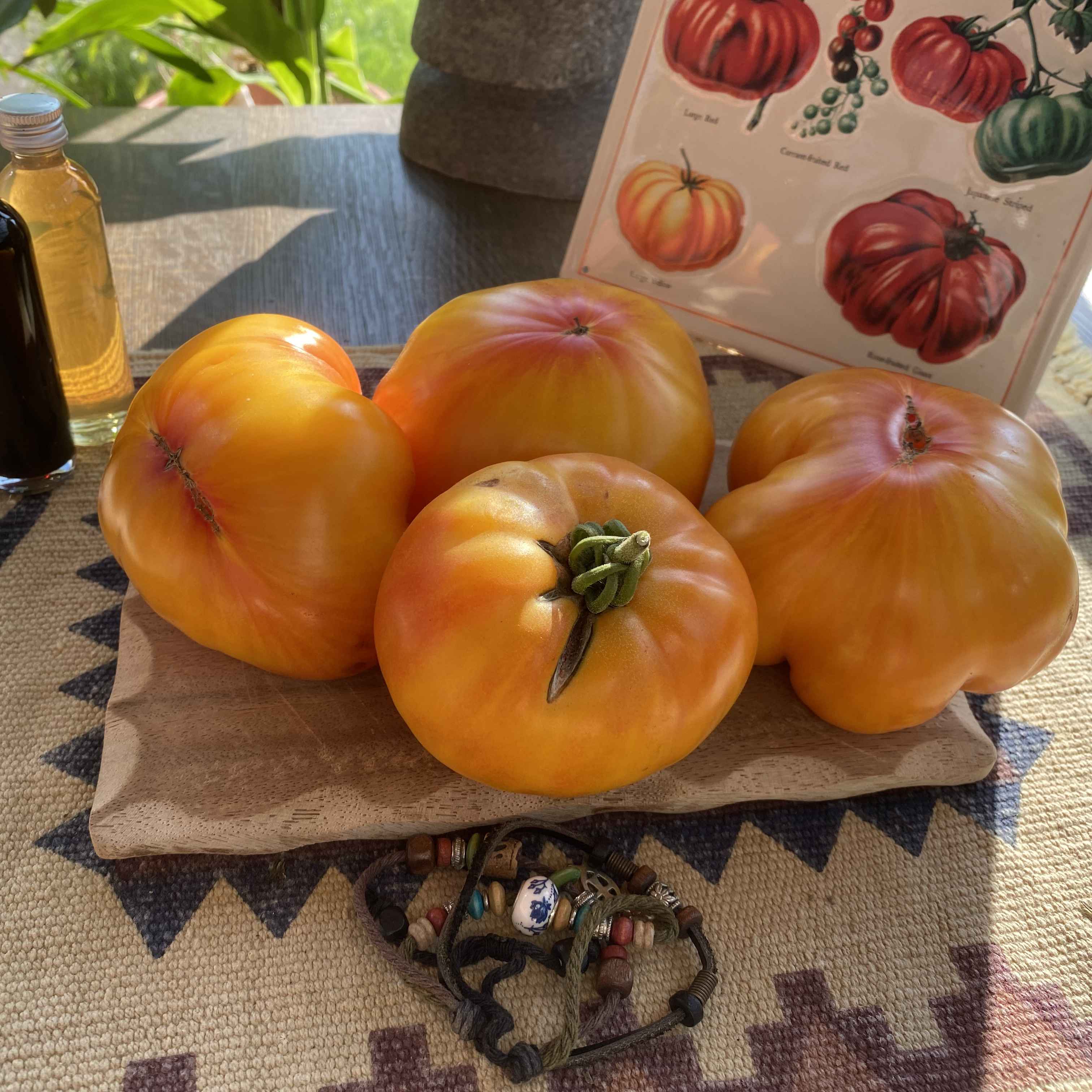Vier orange Tomaten auf einem Brett