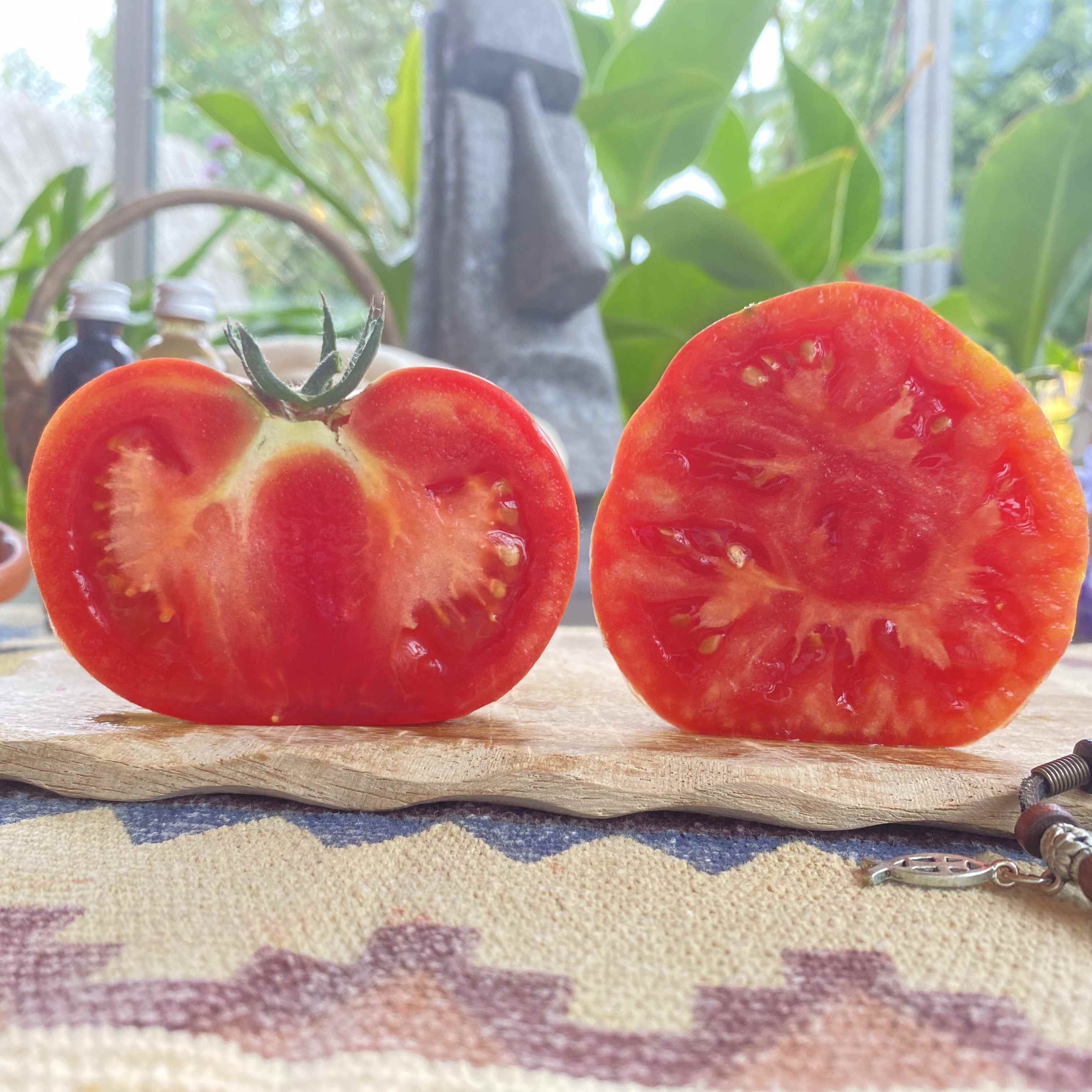 Eine quer und länglich halbierte Tomatenfrucht auf einem BRett