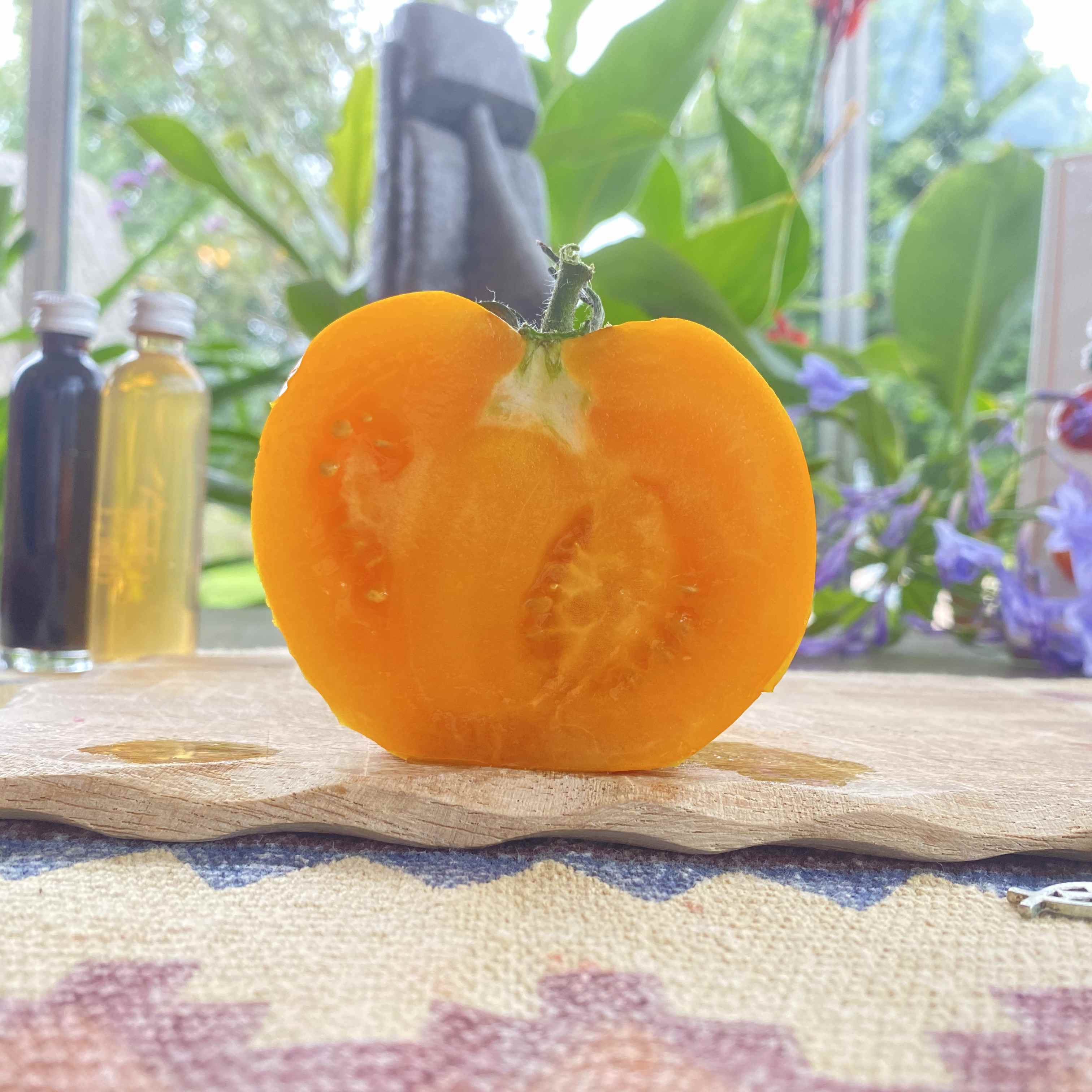 Eine länglich aufgeschnittene gelbe Tomatenfrucht auf einem Brett