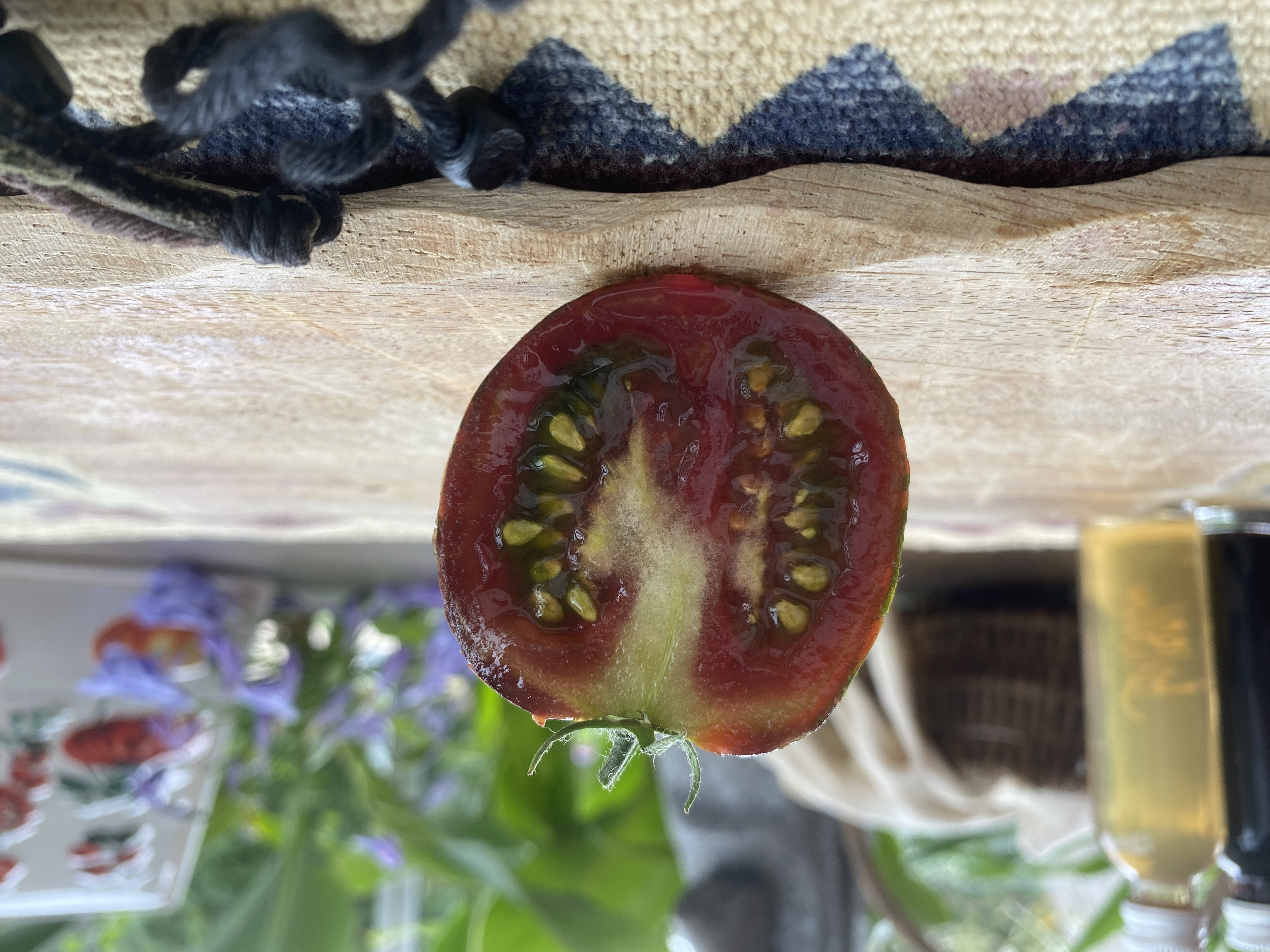 Eine braune länglich halbierte Tomatenfrucht auf einem Brett